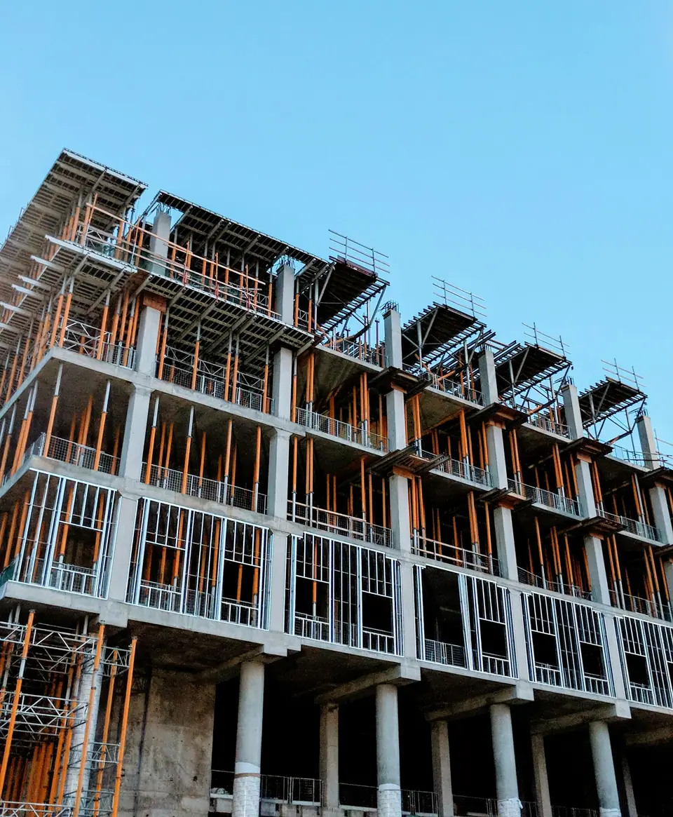 A multi-storey residential building under construction with a steel frame